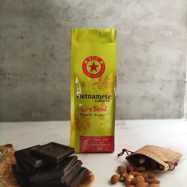 A bag of Nua blend Vietnamese coffee. Pictured with squares of dark chocolate and a small sack of hazelnuts.
