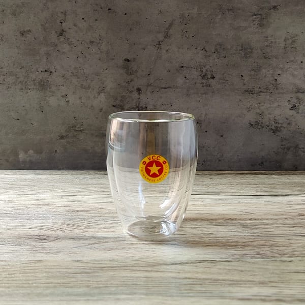 A large double walled coffee glass with circular Vietnamese Coffee Co. logo in red and yellow.